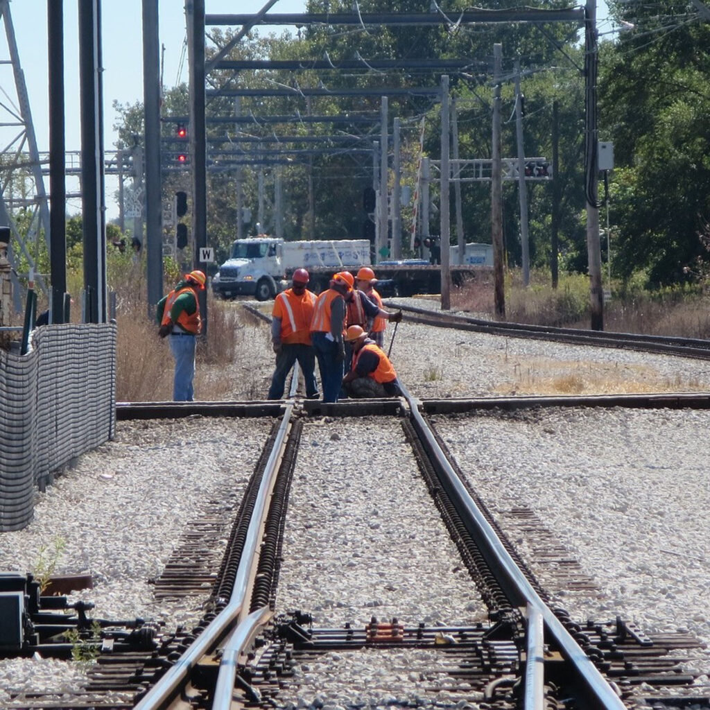 Plusieurs ouvriers qui changent des rails de train